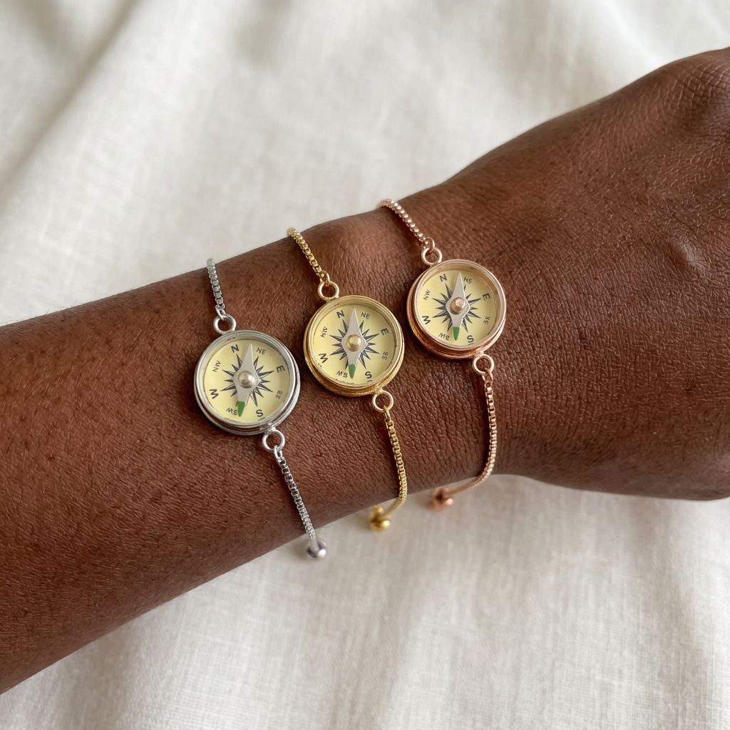 Silver, gold, and rose gold Working Compass Bracelets on a darker-skinned woman's wrist